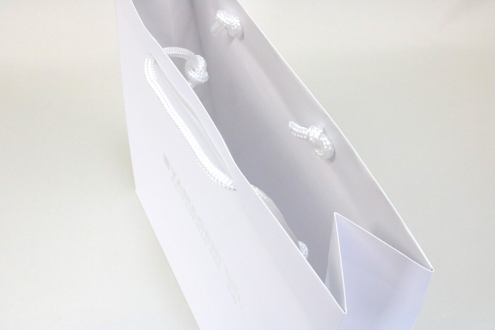 コート紙（白）表面マットPP貼り、箔押印刷 銀艶１色の別注名入れ紙袋の入れ口画像