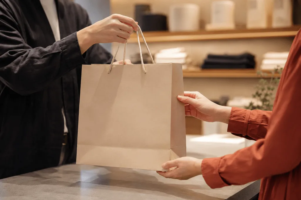 店舗で紙製ショッパーを受け取る様子